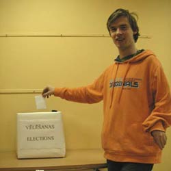 Mann, der einen Stimmzettel in eine Box wirft